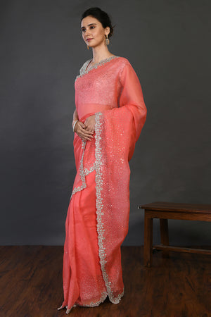 Shop coral cutdana work organza sari online in USA with blouse. Make a fashion statement on festive occasions and weddings with designer sarees, designer suits, Indian dresses, Anarkali suits, palazzo suits, designer gowns, sharara suits, embroidered sarees from Pure Elegance Indian fashion store in USA.-pallu