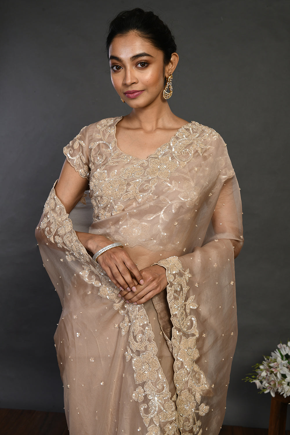 Shop beige embroidered organza sari online in USA with sequin border. Make a fashion statement on festive occasions and weddings with designer sarees, designer suits, Indian dresses, Anarkali suits, palazzo suits, designer gowns, sharara suits, embroidered sarees from Pure Elegance Indian fashion store in USA.-closeup