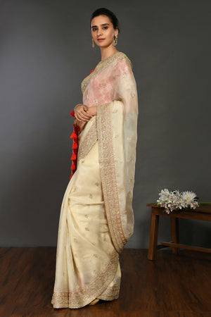 Buy cream hand embroidered organza sari online in USA with red bandhej blouse. Make a fashion statement on festive occasions and weddings with designer sarees, designer suits, Indian dresses, Anarkali suits, palazzo suits, designer gowns, sharara suits, embroidered sarees from Pure Elegance Indian fashion store in USA.-side
