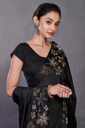 Shop black Swarovski floral motifs satin sari online in USA with blouse. Make a fashion statement on festive occasions and weddings with designer sarees, designer suits, Indian dresses, Anarkali suits, palazzo suits, designer gowns, sharara suits, embroidered sarees from Pure Elegance Indian fashion store in USA.-closeup