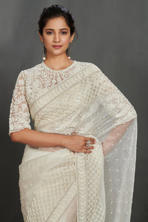 Buy off-white embroidered organza saree online in USA with lace border. Make a fashion statement on festive occasions and weddings with designer sarees, designer suits, Indian dresses, Anarkali suits, palazzo suits, designer gowns, sharara suits, embroidered sarees from Pure Elegance Indian fashion store in USA.-closeup