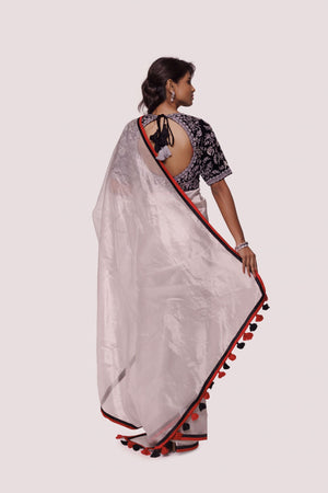Shop grey-black organza saree featuring tikki and cut dana work, tassels embroidered velvet blouse detailing is a perfect choice for parties! It comes with a designer saree blouse. Make a fashion statement at weddings with stunning designer sarees, embroidered sarees with blouses, wedding sarees, and handloom sarees from Pure Elegance Indian fashion store in the USA.