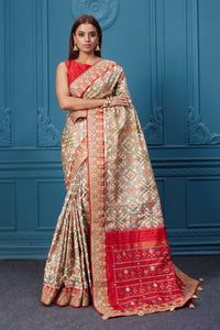 Buy off-white Patola silk saree online in USA with red embroidered border and saree blouse. Look royal at weddings and festive occasions in exquisite designer sarees, handwoven sarees, pure silk saris, Banarasi sarees, Kanchipuram silk sarees from Pure Elegance Indian saree store in USA. -full view