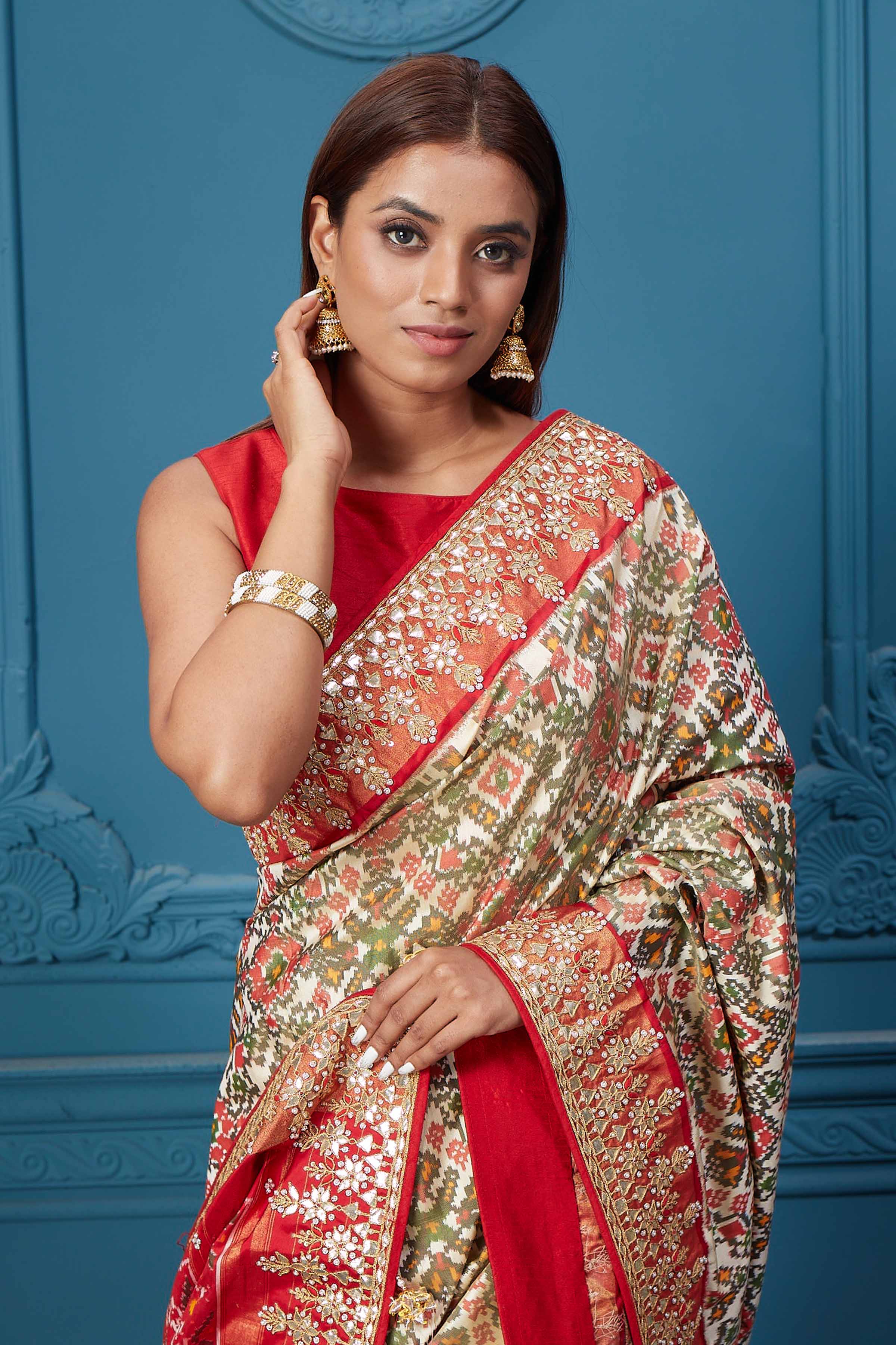 Buy off-white Patola silk saree online in USA with red embroidered border and saree blouse. Look royal at weddings and festive occasions in exquisite designer sarees, handwoven sarees, pure silk saris, Banarasi sarees, Kanchipuram silk sarees from Pure Elegance Indian saree store in USA. -closeup