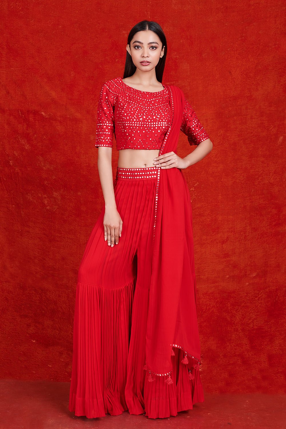 Buy stunning red mirror work sharara suit online in USA with dupatta.  Make a fashion statement on festive occasions and weddings with designer suits, Indian dresses, Anarkali suits, palazzo suits, designer gowns, sharara suits from Pure Elegance Indian fashion store in USA.-front