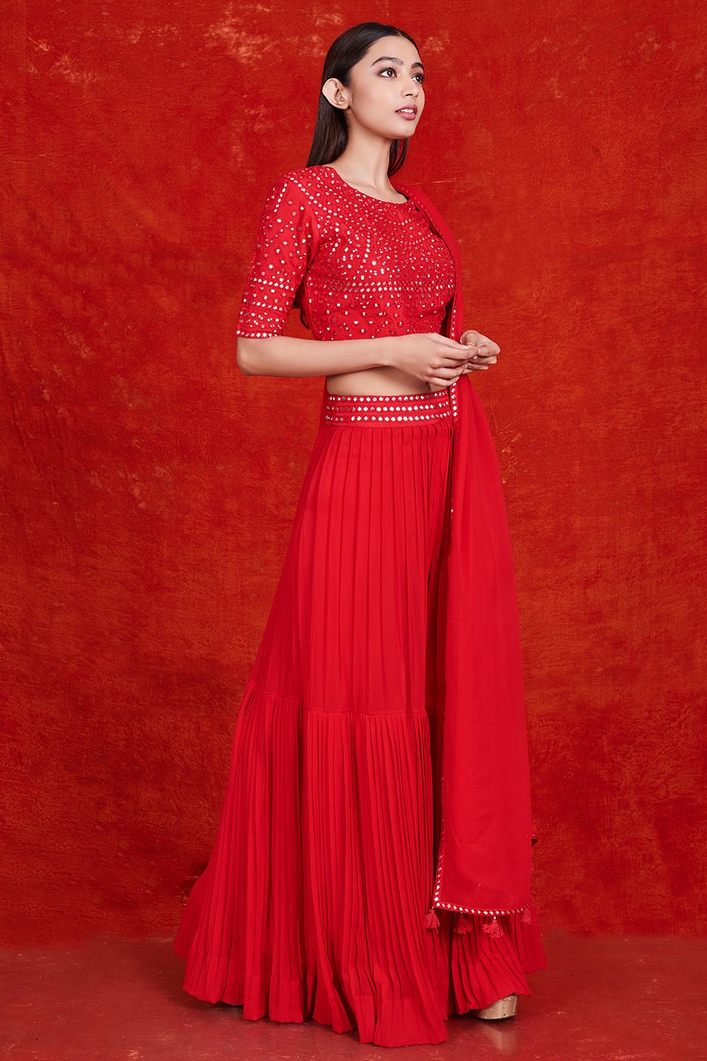 Buy stunning red mirror work sharara suit online in USA with dupatta.  Make a fashion statement on festive occasions and weddings with designer suits, Indian dresses, Anarkali suits, palazzo suits, designer gowns, sharara suits from Pure Elegance Indian fashion store in USA.-right