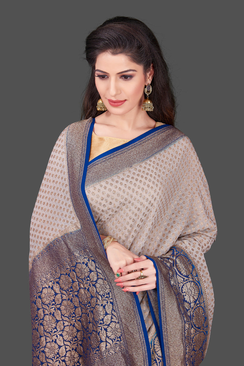 Buy light grey georgette Benarasi sari online in USA with blue zari border. Shop beautiful Banarasi sarees, georgette sarees, pure muga silk sarees in USA from Pure Elegance Indian fashion boutique in USA. Get spoiled for choices with a splendid variety of Indian saris to choose from! Shop now.-closeup