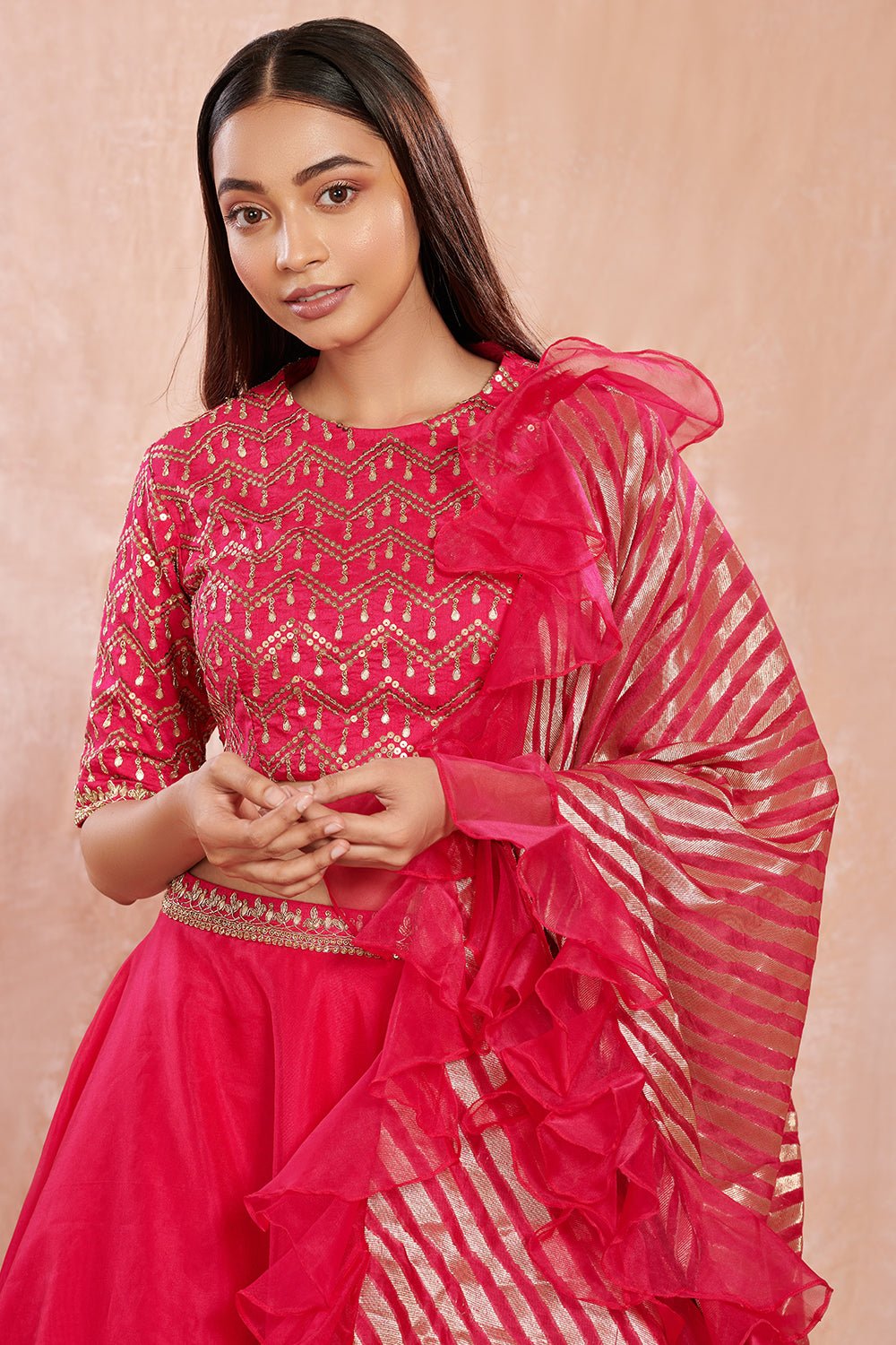 Shop stunning rani pink organza lehenga online in USA with ruffled dupatta. Make a fashion statement on festive occasions and weddings with designer suits, Indian dresses, Anarkali suits, palazzo suits, designer gowns, sharara suits from Pure Elegance Indian fashion store in USA.-closeup