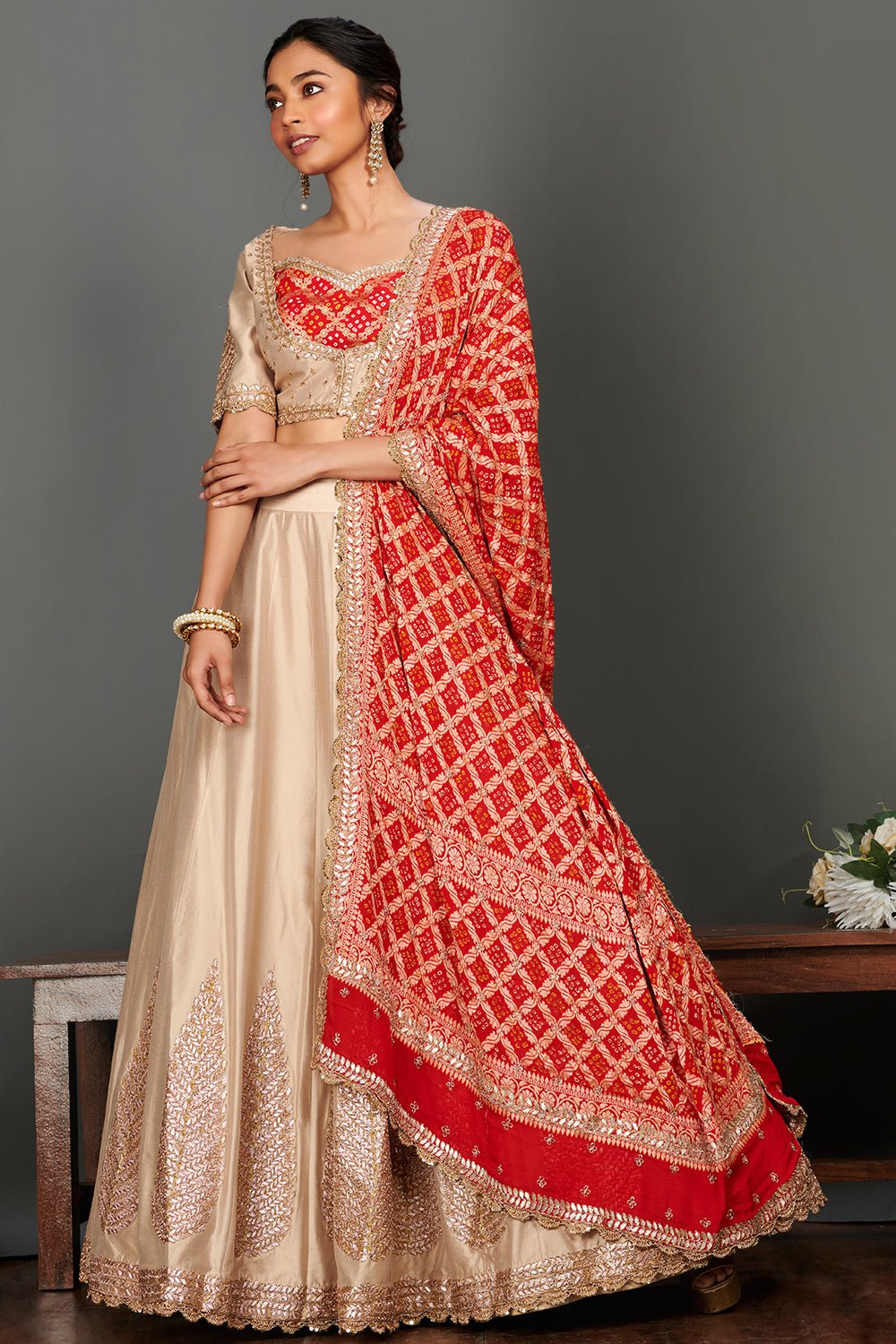 Shop stunning beige embroidered lehenga online in USA with red bandhej dupatta. Make a fashion statement on festive occasions and weddings with palazzo suits, sharara suits, partywear dresses, salwar suits from Pure Elegance Indian fashion store in USA.-full view