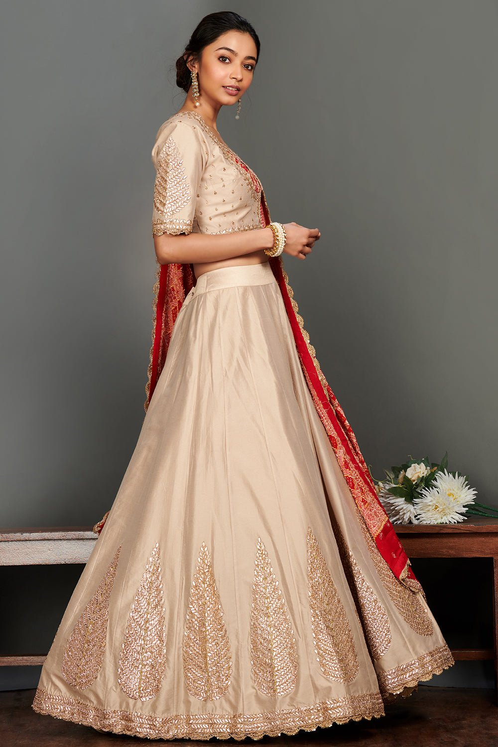 Shop stunning beige embroidered lehenga online in USA with red bandhej dupatta. Make a fashion statement on festive occasions and weddings with palazzo suits, sharara suits, partywear dresses, salwar suits from Pure Elegance Indian fashion store in USA.-side