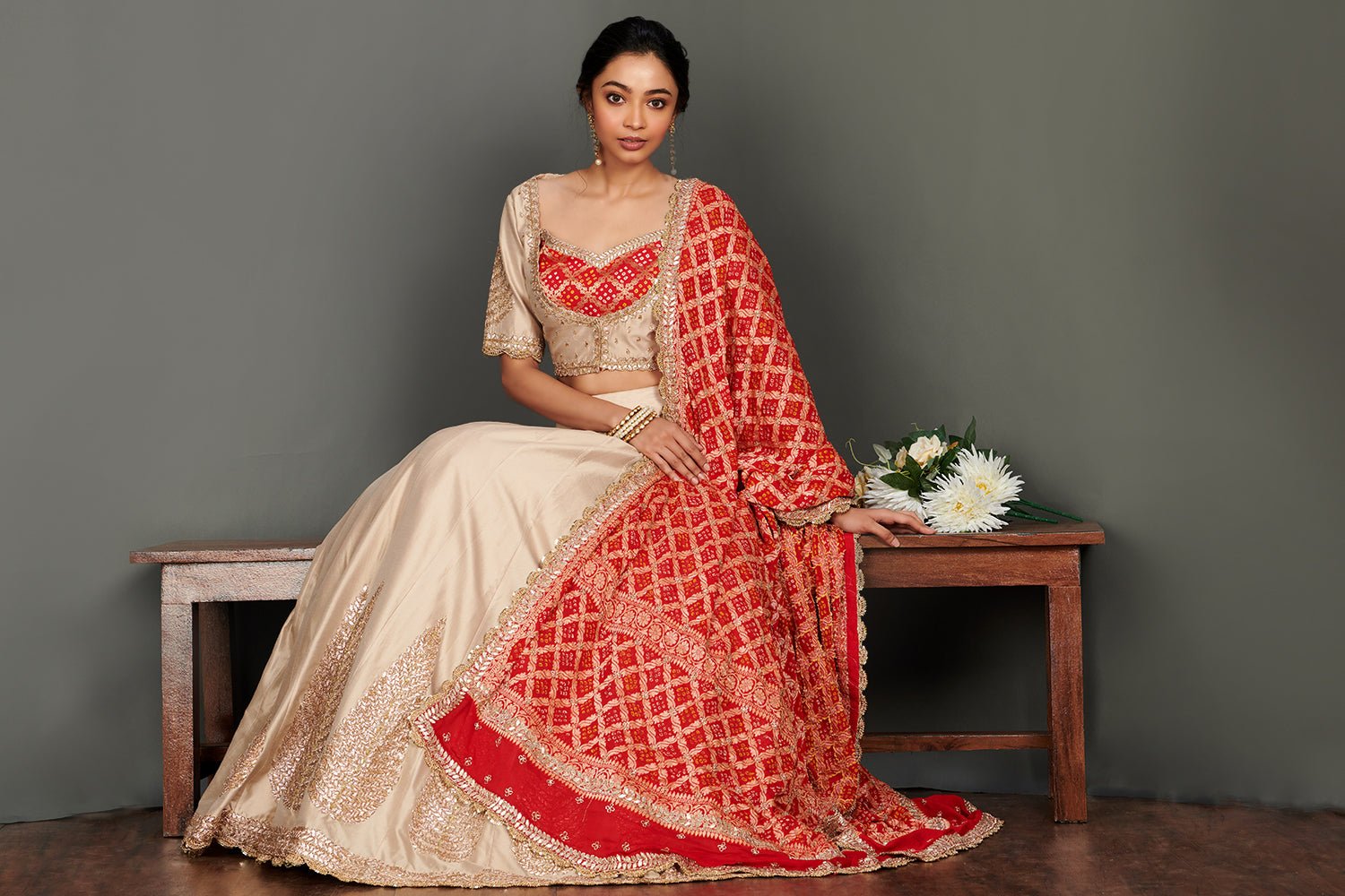 Shop stunning beige embroidered lehenga online in USA with red bandhej dupatta. Make a fashion statement on festive occasions and weddings with palazzo suits, sharara suits, partywear dresses, salwar suits from Pure Elegance Indian fashion store in USA.-sitting