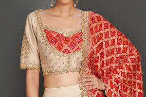 Shop stunning beige embroidered lehenga online in USA with red bandhej dupatta. Make a fashion statement on festive occasions and weddings with palazzo suits, sharara suits, partywear dresses, salwar suits from Pure Elegance Indian fashion store in USA.-closeup