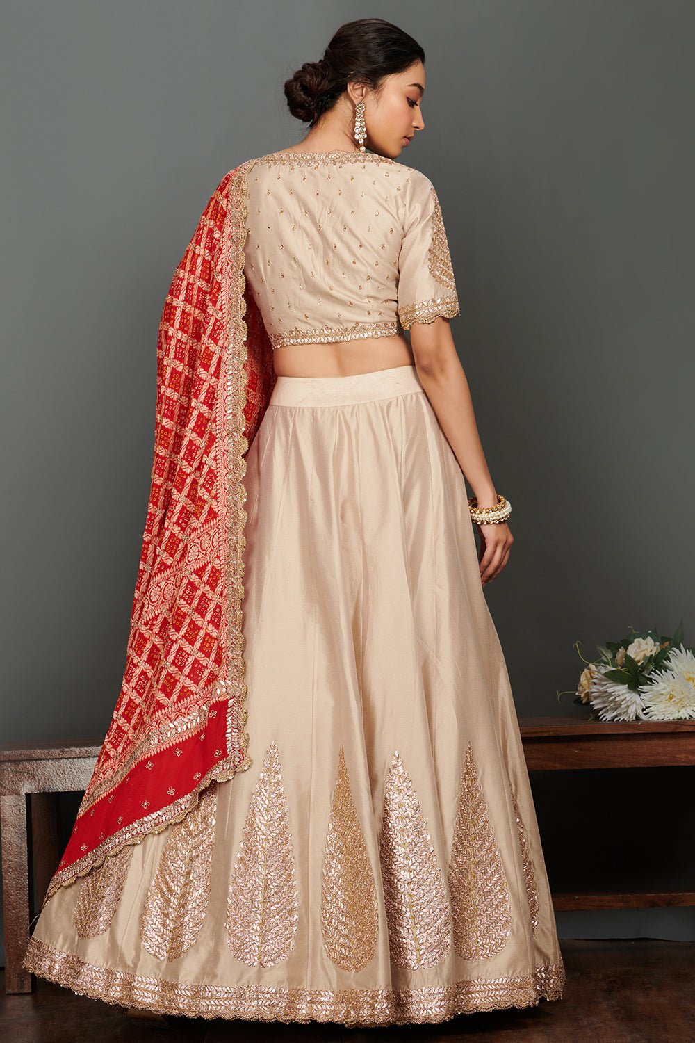 Shop stunning beige embroidered lehenga online in USA with red bandhej dupatta. Make a fashion statement on festive occasions and weddings with palazzo suits, sharara suits, partywear dresses, salwar suits from Pure Elegance Indian fashion store in USA.-back