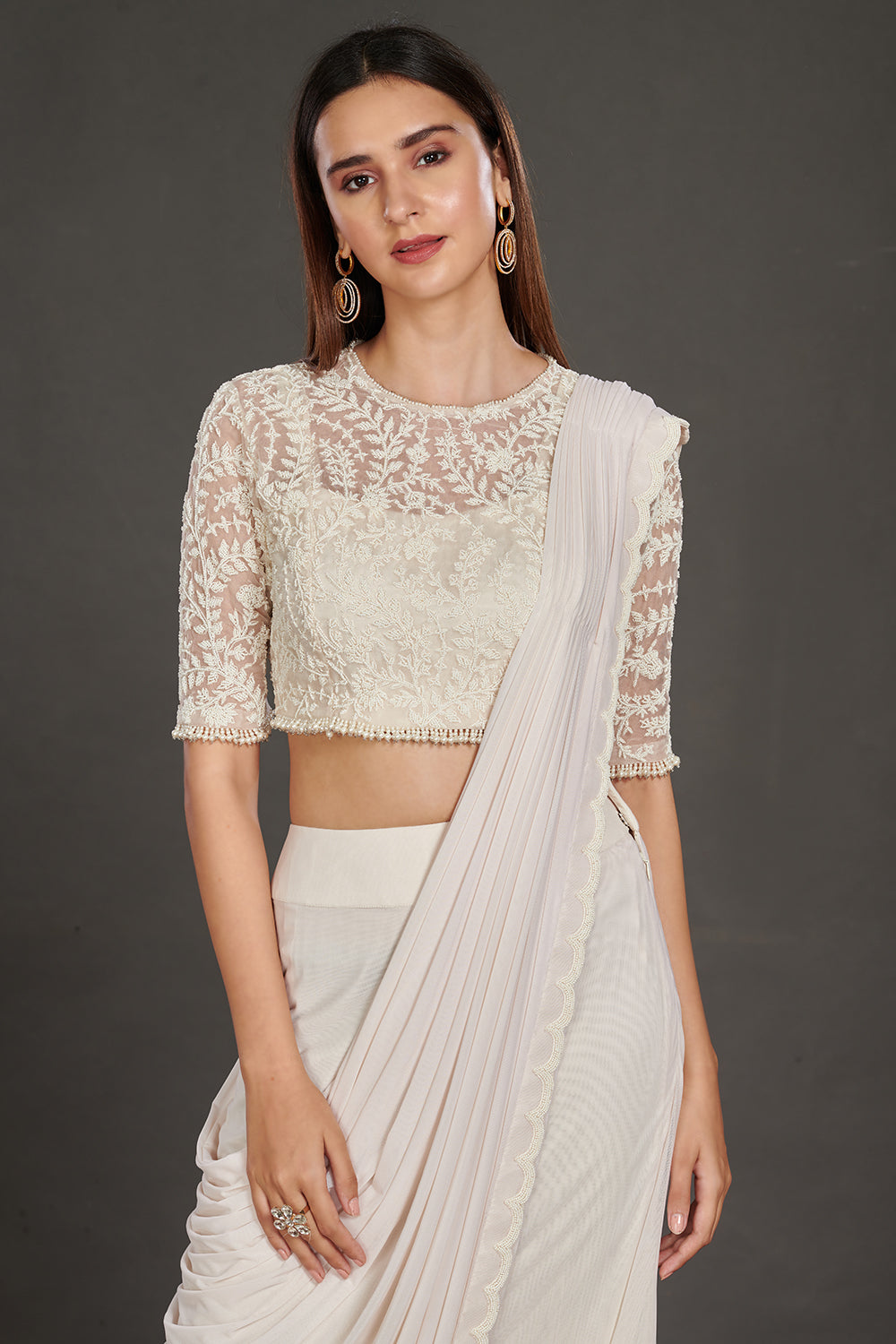 Shop stunning off-white satin saree online in USA with strappy blouse with crop jacket. Make a fashion statement on festive occasions and weddings with designer suits, Indian dresses, Anarkali suits, palazzo suits, designer gowns, sharara suits from Pure Elegance Indian fashion store in USA.-closeup