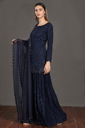 Buy stunning navy blue shimmer sharara suit online in USA. Make a fashion statement on festive occasions and weddings with palazzo suits, sharara suits, partywear dresses, salwar suits from Pure Elegance Indian fashion store in USA.-left