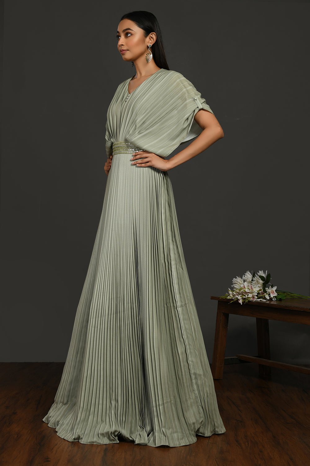 Buy stunning tea green pleated gown online in USA with metallic belt. Make a fashion statement on festive occasions and weddings with designer suits, Indian dresses, Anarkali suits, palazzo suits, designer gowns, sharara suits from Pure Elegance Indian fashion store in USA.-left