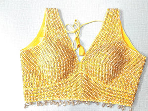 Buy a beautifully designed yellow color pearl embroidered readymade saree blouse. This saree blouse is a must-have piece this wedding season. Wear it with a contrasting saree or even with a contrasting lehenga skirt to complete the look. Elevate your Indian ethnic sarees with beautiful readymade sari blouses, embroidered saree blouses, Banarasi saree blouse, designer sari blouses, choli-cut blouses from Pure Elegance Indian fashion store in USA.-50x986