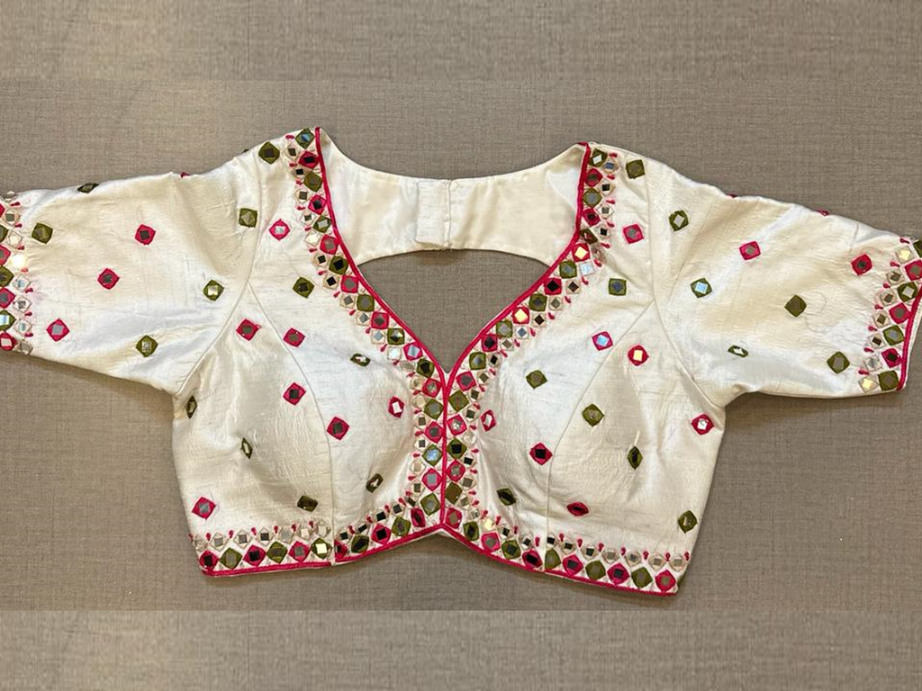 Buy Tailored in a timeless hue and topped with multicolor thread and mirror work details, this blouse is an evergreen addition to your festive wardrobe and party look. It is designed with a V neckline, 3/4th sleeves, and back hook closure. Buy this designer blouse in the USA from Pure Elegance. 