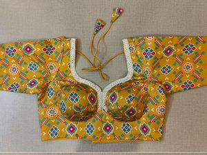 Buy women's yellow Ajrakh Block Printed, padded Saree Blouse that has a round neck, Hook & tie-up closure at back with 3/4th sleeves. Classic is never old and enough to have in your closet!! Pair this fashionable blouse with a beautifully printed sari and statement neckpiece and you are good to go! Buy this designer blouse in the USA from Pure Elegance.- Front View