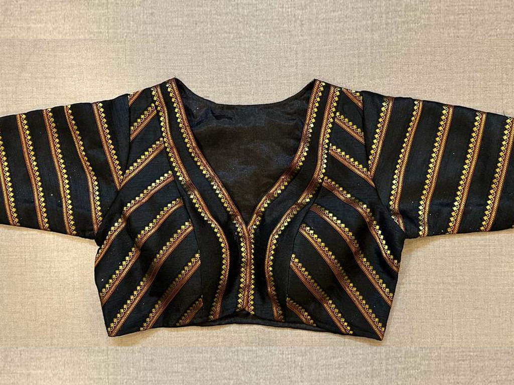 Buy a tailored in a timeless hue and topped with stripped details, this black blouse is an evergreen addition to your festive wardrobe and party look. It is designed with a V neckline, 3/4th sleeves, and back hook closure. Buy this designer blouse in the USA from Pure Elegance. 