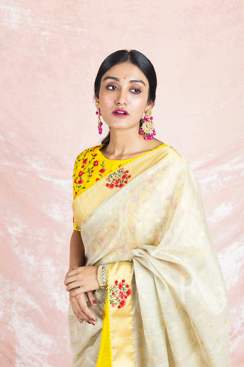 Buy beautiful cream embroidered handloom saree online in USA with embroidered yellow sari blouse. Champion ethnic fashion on weddings and festivals with a stunning collection of Banarasi sarees, handloom sarees with blouse, bridal sarees, from Pure Elegance Indian fashion store in USA.-closeup