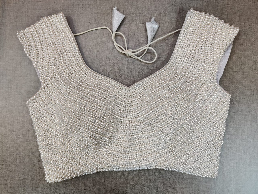 Shop stunning white pearl work designer saree blouse online in USA. Elevate your Indian ethnic saree looks with beautiful readymade saree blouse, embroidered saree blouses, Banarasi saree blouse, designer sari blouses from Pure Elegance Indian fashion store in USA.-front