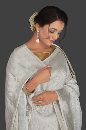 Shop white tassar georgette Banarsi saree online in USA with silver zari border. Radiate elegance with handloom sarees with blouse, tussar silk saris, Banarsi sarees from Pure Elegance Indian fashion boutique in USA. We bring a especially curated collection of ethnic saris for Indian women in USA under one roof!-closeup