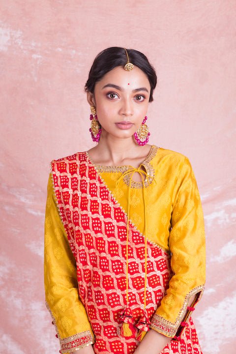 Shop stunning yellow designer sharara suit online in USA with red draped Bandhej dupatta. Champion ethnic fashion on weddings and festivals with a stunning collection of designer Indian dresses, Indowestern outfits, salwar suits, Anarkali suits from Pure Elegance Indian fashion store in USA.-closeup