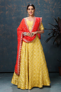 Shop beautiful yellow crepe Banarasi lehenga online in USA with red dupatta. Flaunt Indian style at parties and weddings in beautiful designer dresses, salwar suits, Anarkali suits, gowns, palazzo suits from Pure Elegance Indian fashion store in USA.-full view