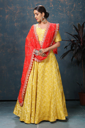 Shop beautiful yellow crepe Banarasi lehenga online in USA with red dupatta. Flaunt Indian style at parties and weddings in beautiful designer dresses, salwar suits, Anarkali suits, gowns, palazzo suits from Pure Elegance Indian fashion store in USA.-front