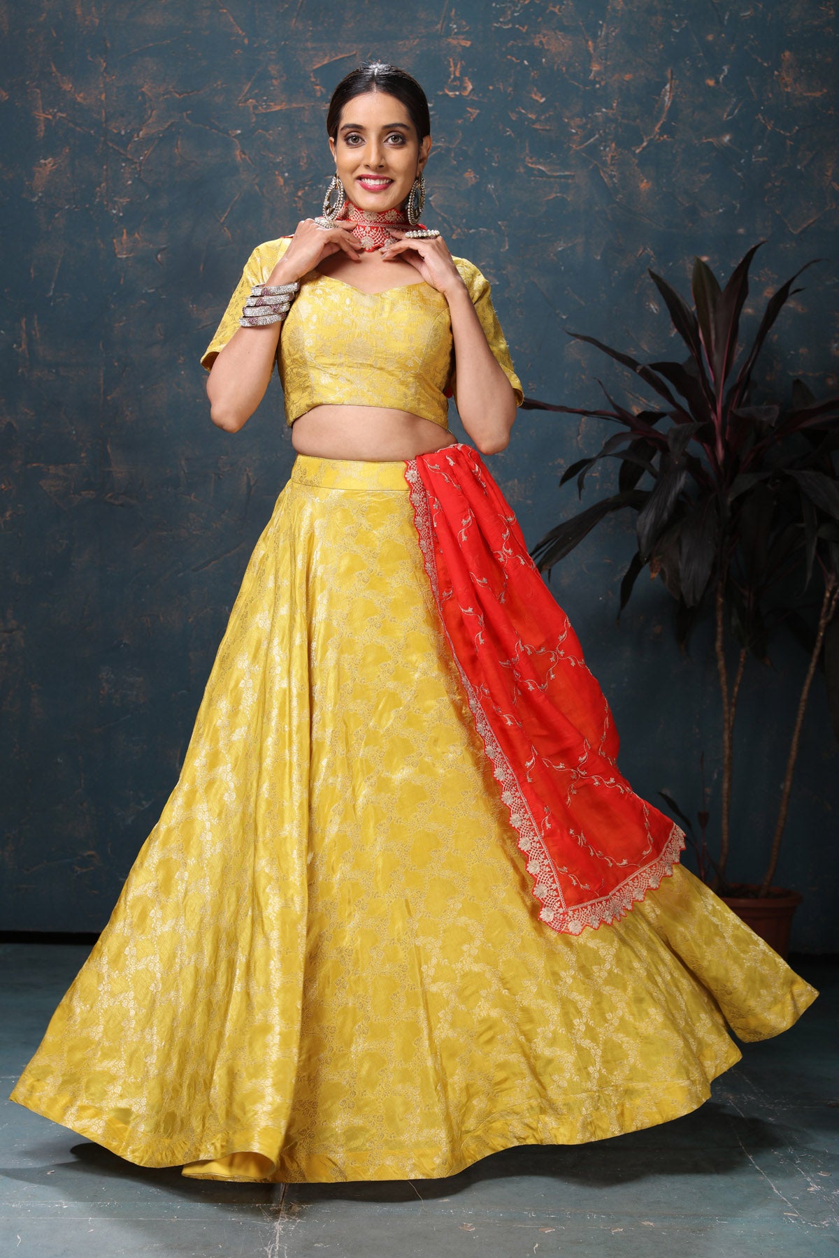 Shop beautiful yellow crepe Banarasi lehenga online in USA with red dupatta. Flaunt Indian style at parties and weddings in beautiful designer dresses, salwar suits, Anarkali suits, gowns, palazzo suits from Pure Elegance Indian fashion store in USA.-lehenga