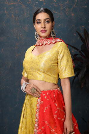 Shop beautiful yellow crepe Banarasi lehenga online in USA with red dupatta. Flaunt Indian style at parties and weddings in beautiful designer dresses, salwar suits, Anarkali suits, gowns, palazzo suits from Pure Elegance Indian fashion store in USA.-closeup
